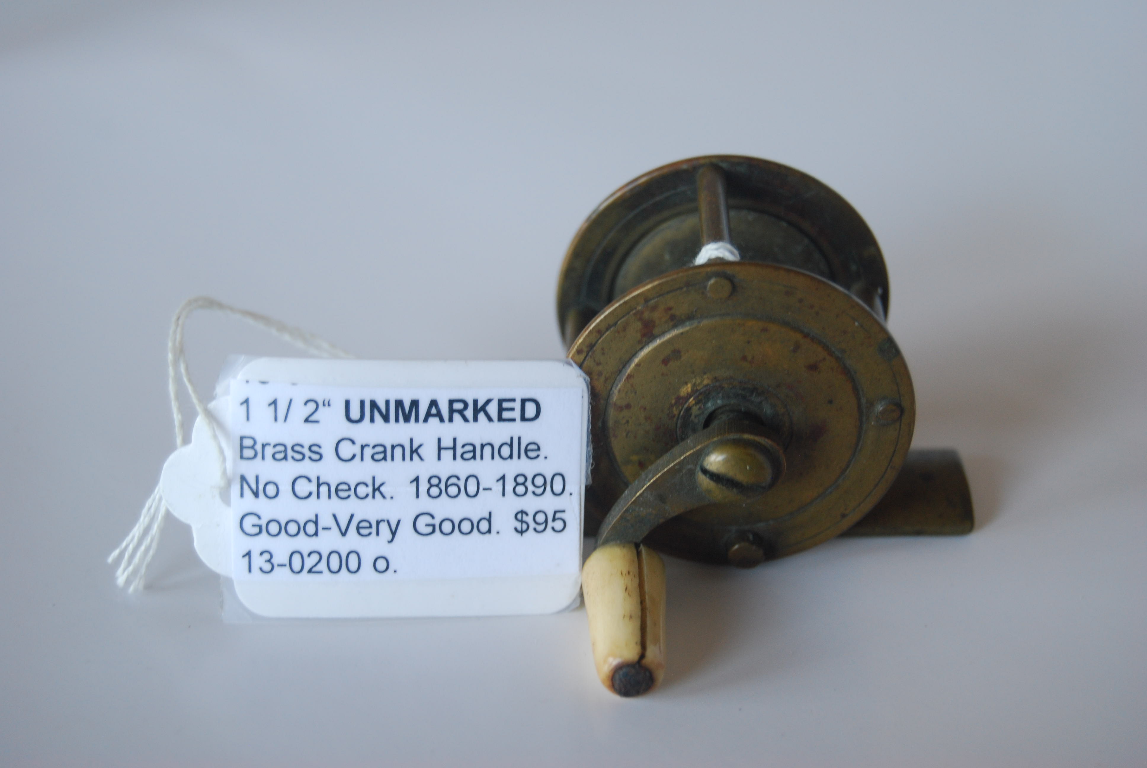 Image for 1 1/2” UNMARKED Brass Crank-handle reel. 7/8 in. pillars; No Check; White Bone knob on curved crank handle; Circa 1860-1890. 2 3/8 oz.